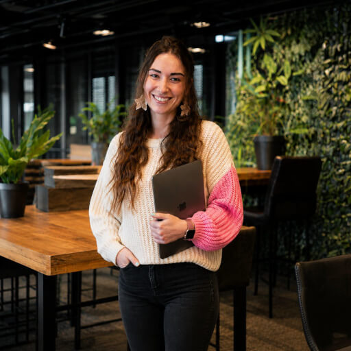Nata van Houdt standing beside a table in a plant-filled workspace